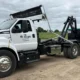 TNT Rolloffs roll-off dumpster truck delivering dumpster rental in Franklin, IN