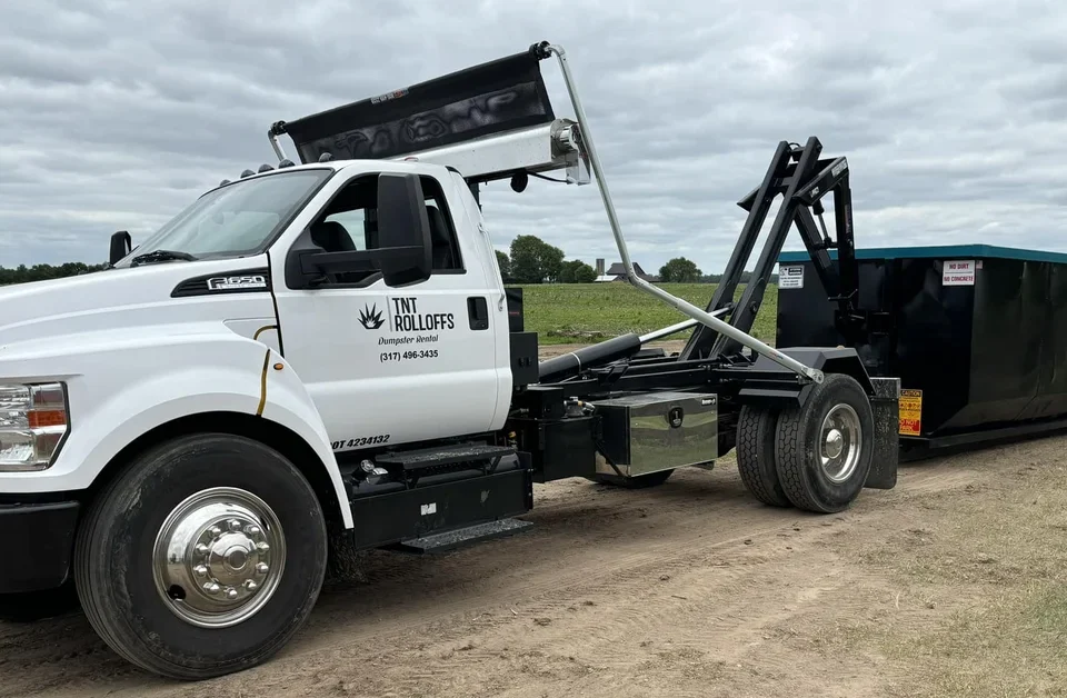 TNT Rolloffs roll-off dumpster truck delivering dumpster rental in Franklin, IN