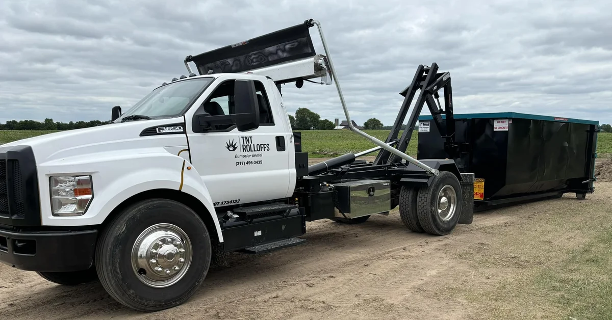 TNT Rolloffs roll-off dumpster truck delivering dumpster rental in Franklin, IN